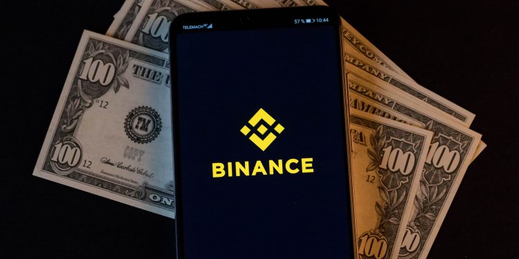 mobile phone and binance logo on dollars cc by 20 scaled